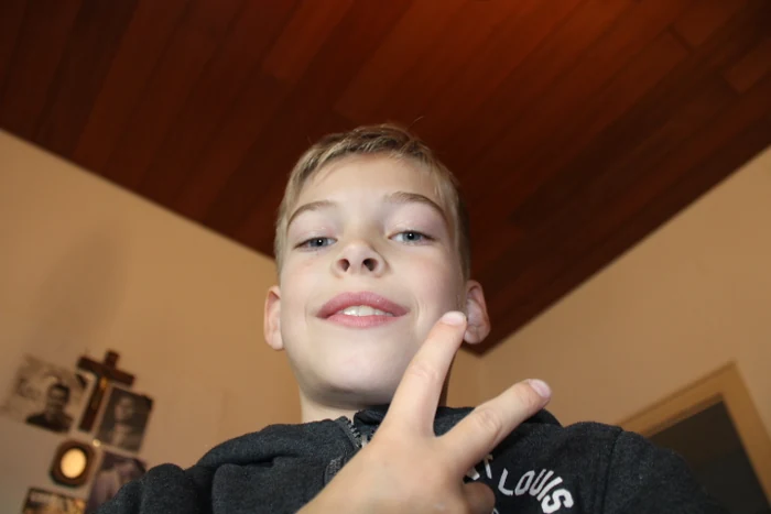 Ein Junge hält zwei Finger als Friedenszeichen in die Kamera.